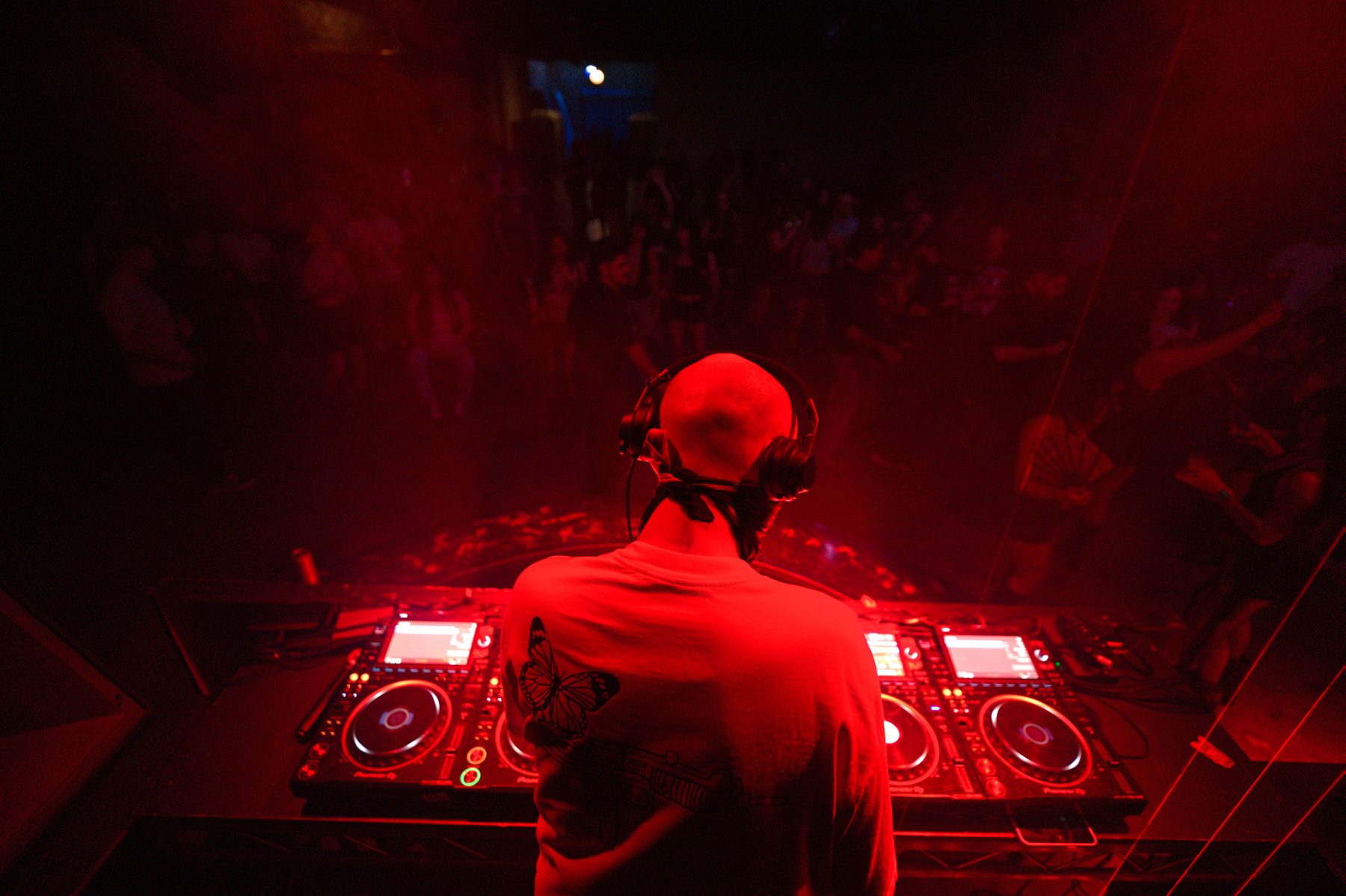 NOWHERE INC. seen only from behind in the booth, facing the room